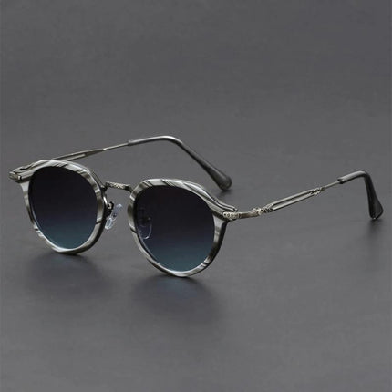 Gafas de sol retro Helios con lentes redondos, armazón metálico esculpido plateado y protección UV400, estilo vintage moderno.