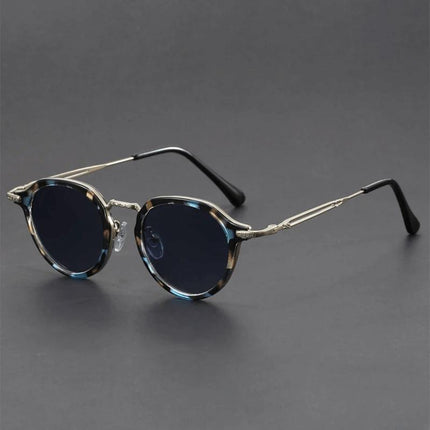 Anteojos de sol retro Helios con lentes redondos oscuros, patillas metálicas esculpidas y marco color carey, unisex, estilo vintage.