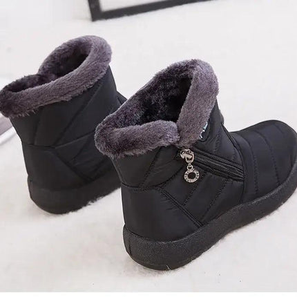 Bota impermeable color negro con abrigo de felpa gris, diseño moderno para invierno, ideal para mujeres.