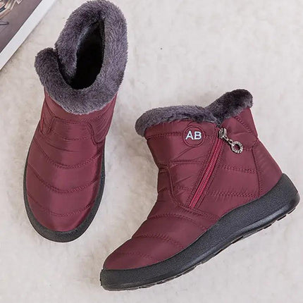 Bota impermeable para mujer color burdeos, felpa interior gris, diseño moderno con cierre lateral.