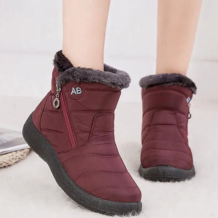 Bota impermeable chic color burdeos para mujer, diseño moderno con felpa y taco bajo, ideal para invierno.