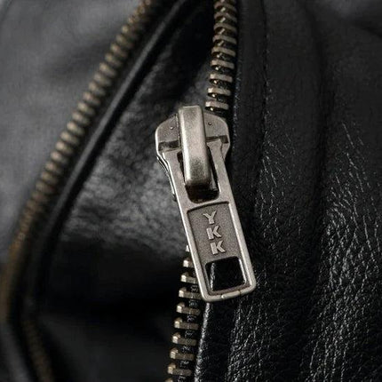 Cierre metálico de campera de cuero vacuno negra, diseño para adultos, detalle en primer plano del material.