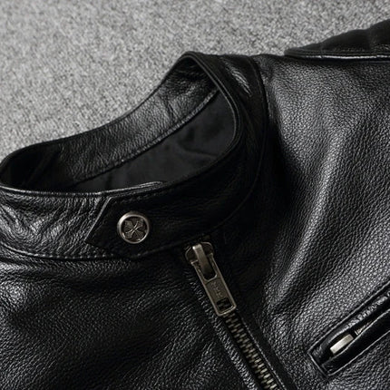 Campera negra de cuero vacuno para adultos, diseño clásico y cierre metálico, sobre fondo gris claro.