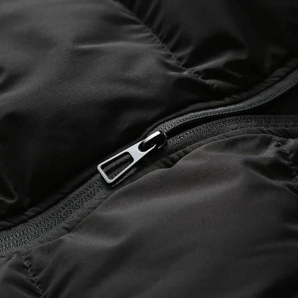 Detalle cremallera Chaleco ThermoShield sin mangas negro para hombres con capucha desmontable, ideal climas fríos.