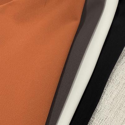 Muestra de tela de jersey ultraliviano en colores terracota, gris y negro, ideal para ropa de verano y uso versátil.