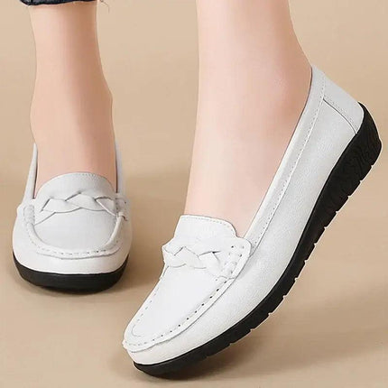 Mocasines de cuero blancos para mujer, diseño clásico con suela negra. Elegancia y comodidad para todo el día.