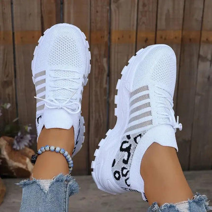 Zapatillas blancas WildFit para mujer, tejido knit elástico, suela deportiva, detalle animal print en el talón.