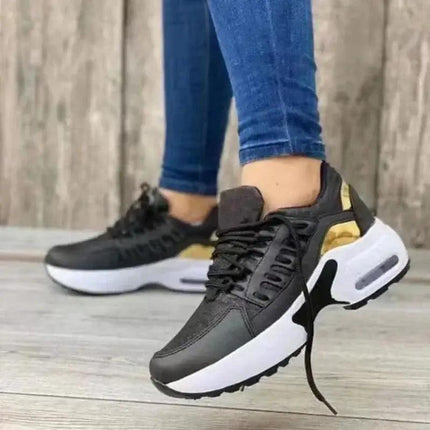 Zapatillas mujer Zenithi Flow negras y doradas, estilo urbano, suela blanca, diseño liviano y respirable para mujeres activas.