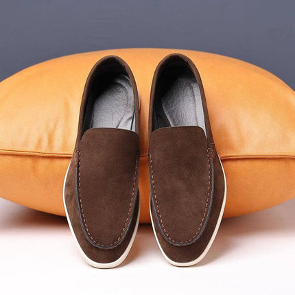 Zapatos marrones sin cordones de gamuza para hombre sobre cojín, diseño casual y confortable.