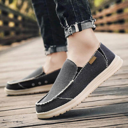 Zapatos de lona gris transpirables para hombres, estilo informal, en un paseo de madera, diseño moderno.