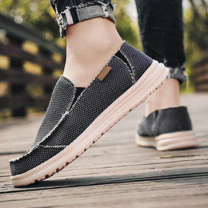 Zapatos informales de lona negra transpirables para hombre, ideal para uso diario, cómodos y con suela blanca.
