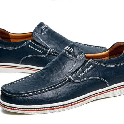 Zapatos mocasín de cuero azul oscuro para hombre, estilo casual, con costuras blancas y suela blanca, elegante y moderno.